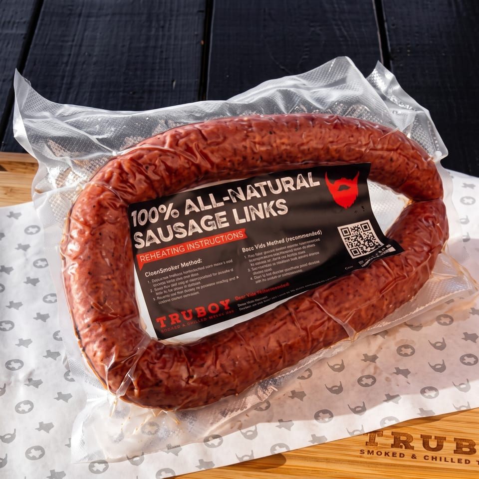 Packaged loop of all-natural sausage links labeled Truboy, displayed on branded butcher paper and a wooden counter.